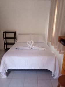 a white bed with two white towels on it at Casa Nas Montanhas Capixabas in Domingos Martins