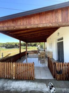 a porch with a wooden deck with a fence at Cozy 5-Bed Home with Balcony in Velipojë