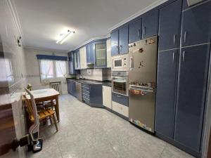 a kitchen with blue cabinets and a table in it at Peris in Gijón