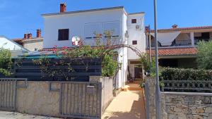 a white house with a fence with flowers on it at Apartments Alex in Rovinj +22 photos