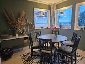 a dining room with a table and chairs and windows at Privat Spirit Spa Villa in Vallentuna