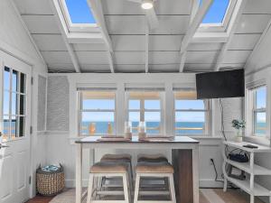 a kitchen with a table with stools and windows at 251 Old Wharf Road Unit 57 Dennis Port - Blue Horizon in Dennis Port