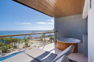 d'un balcon avec une baignoire et une vue sur l'océan. dans l'établissement Radisson Blu Resort Gran Canaria, à Playa de Arguineguín