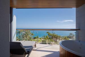 uma casa de banho com banheira e vista para o oceano em Radisson Blu Resort Gran Canaria em La Playa de Arguineguín
