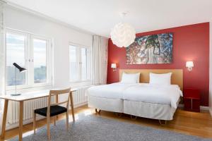 a bedroom with a large white bed and a desk at Radisson Blu Aleksanteri Hotel, Helsinki in Helsinki