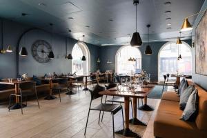 a restaurant with tables and chairs and a clock on the wall at Radisson Blu Aleksanteri Hotel, Helsinki in Helsinki