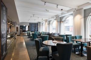 a dining room with tables and chairs and windows at Radisson Blu Aleksanteri Hotel, Helsinki in Helsinki
