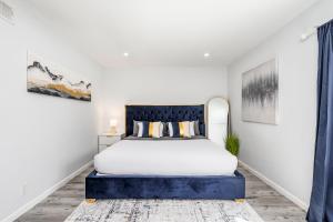 a bedroom with a king sized bed with a blue headboard at Mins to Disney Chic 3BR with Arcade in Santa Ana +30 photos