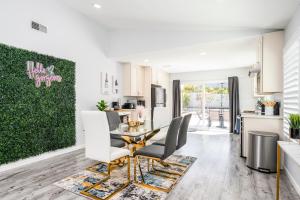 a kitchen and dining room with a table and chairs at Mins to Disney Chic 3BR with Arcade in Santa Ana