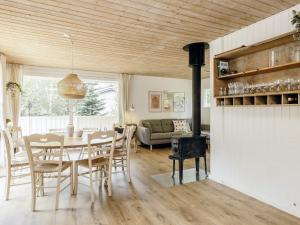 a dining room and living room with a table and chairs at 6 person holiday home in Brovst-By Traum in Brovst +14 photos