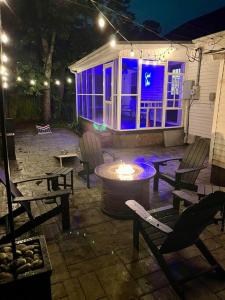 eine Terrasse mit Stühlen und einer Feuerstelle bei Nacht in der Unterkunft Peaceful home in downtown Huntsville with nice back patio! in Huntsville