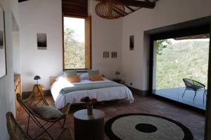 een slaapkamer met een bed en een groot raam bij Casa Vero in Villanueva