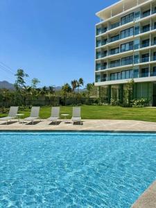 クルス・デ・ウアナカストレにあるzantamar ixchelの大きな建物、スイミングプール(椅子付)