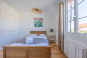 a bedroom with two beds and a window at La Maison du Fleuve - Welkeys in Dives-sur-Mer