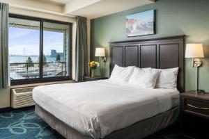 a bedroom with a large bed and a large window at Park Point Marina Inn in Duluth