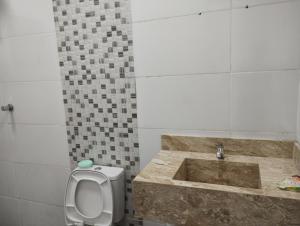 a bathroom with a toilet and a sink at Casa de Praia Golfinhos in Caraguatatuba +19 photos