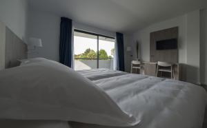 
a bedroom with a bed and a window at Hotel La Palma de Llanes in Llanes

