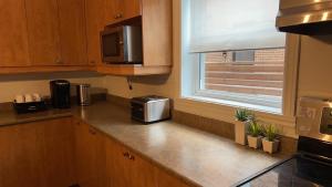 a kitchen with a counter with a microwave and a window at Walk on the riverside in Montréal