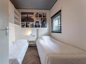 a bedroom with two beds and a window at Beachhouse I in Bergen aan Zee