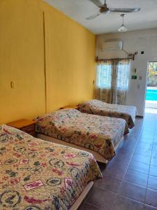 three beds in a room with yellow walls at Villas Yoleth Hotel in Chachalacas