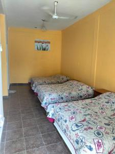 Duas camas num quarto com paredes amarelas em Villas Yoleth Hotel em Chachalacas