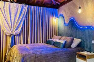 a bedroom with a bed with a blue curtain at chalé das montanhas gravatal cabana águas claras in Gravatal