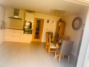 a kitchen with a table and chairs and a clock at GR8 Home in Kingsley