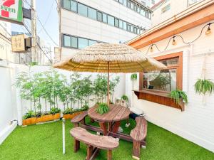 a patio with a table and chairs and an umbrella at Yunseul- Garden House in the City with Korean Beauty in Seoul