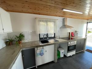 een keuken met een spoelbak en een aanrechtblad bij Longitude 31 House in Faja Grande