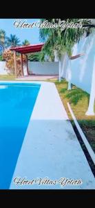 a swimming pool with a picnic table and palm trees at Villas Yoleth Hotel in Chachalacas