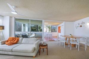 a living room with a couch and a table at Suttons Beach Sunrise in Redcliffe