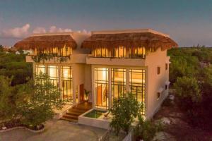 ein großes Haus mit Strohdach in der Unterkunft Crystal Nest SunSet View in Holbox