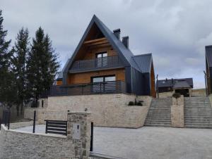 una casa con un tetto nero e delle scale di Luxury villa with a parking space Kupjak, Gorski kotar - 23067 a Kupjak