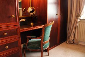 a chair sitting in front of a desk with a mirror at Carnalbanagh House in Portstewart