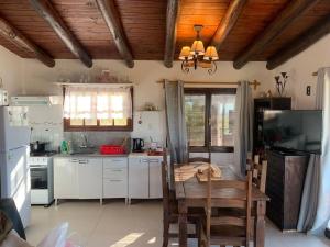 a kitchen with a table and a dining room at Casa MAAT Villa Serrana in Villa Serrana