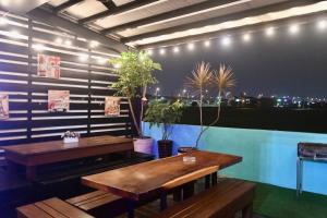 zwei Holztische in einem Zimmer mit Pflanzen an der Wand in der Unterkunft 哦耶Oh Yeah 包棟民宿 in Luodong