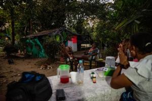 Un grupo de personas sentadas en una mesa en un bosque. en Eco Hospedaje Ata Ladrilleros, en Buenaventura