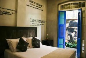 a bedroom with a white bed with a blue door at Modernistas Arte in Rio de Janeiro +2 photos