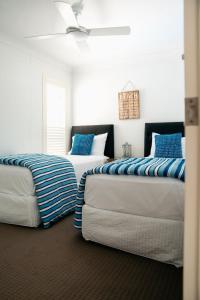 two beds sitting next to each other in a room at Le Beach Apartments in Gold Coast