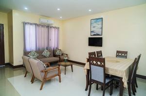 a living room with a table and a dining room at Panglao Village Court Apartment Stay Inn in Panglao
