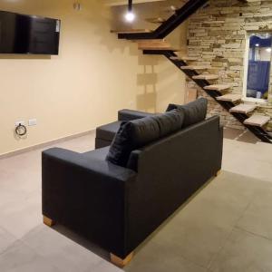 un sofá negro en una sala de estar con TV en Los Menucos Mar Azul, en Mar Azul