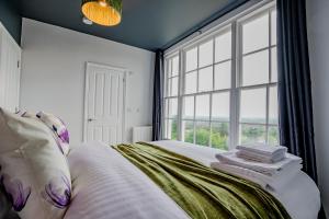 Un dormitorio con una cama con una ventana grande. en Host & Stay - Foley House Apartments, en Great Malvern