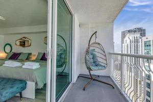 a room with a bed and a swinging chair on a balcony at Oceanside Penthouse Apartment in Brickell Miami, Pool, Free Parking in Miami