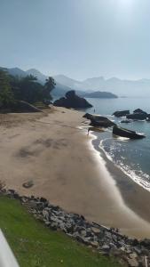 ein leerer Strand mit Felsen und dem Meer in der Unterkunft Casa no Mar de Junqueira in Mangaratiba + 11 Fotos