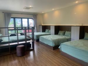 a hotel room with two beds and a window at Châu homestay - Mộc Châu , Sơn La in Mộc Châu