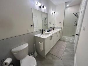 ein Badezimmer mit Toilette, Waschbecken und Spiegel in der Unterkunft Luxury, Home Away from Home in Brampton + 37 Fotos