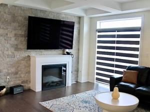 ein Wohnzimmer mit einem Kamin und einem Flachbild-TV in der Unterkunft Luxury, Home Away from Home in Brampton