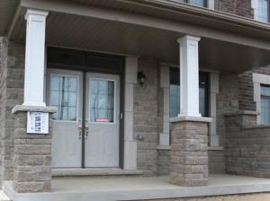 ein Haus mit einer weißen Tür und zwei Säulen in der Unterkunft Luxury, Home Away from Home in Brampton