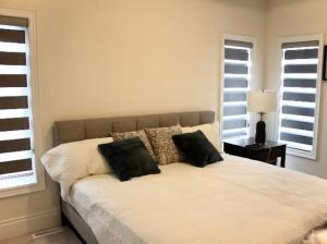 ein Bett mit zwei Kissen darauf in einem Schlafzimmer in der Unterkunft Luxury, Home Away from Home in Brampton