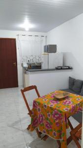 eine Küche mit einem Tisch und einem Blumentischtuch in der Unterkunft Casa no Mar de Junqueira in Mangaratiba